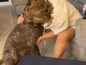 A trusted house sitter giving her furry friend some love and cuddles.